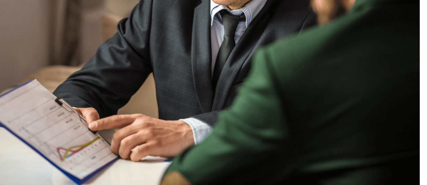 Tax adviser showing a client a clipboard giving year-end tax tips