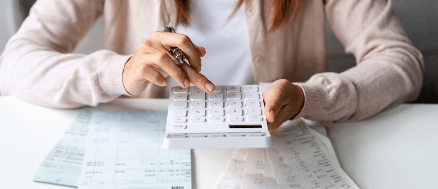 Woman on calculator working on tax basis