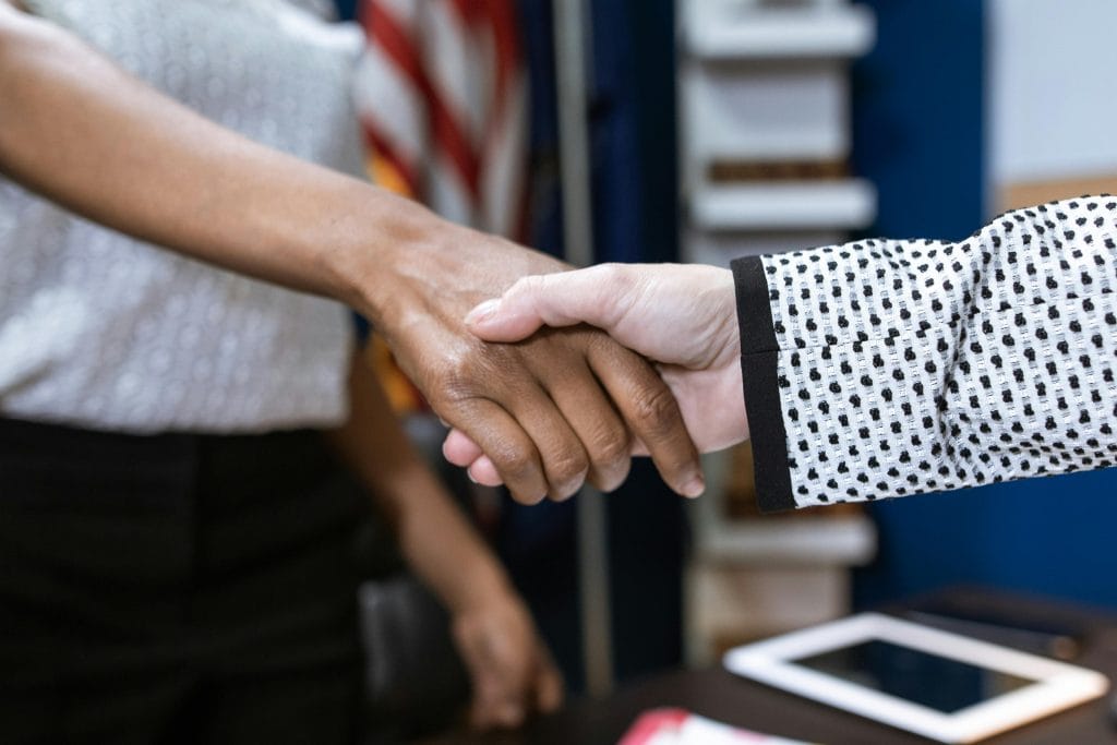 two females in the middle of shaking hands
