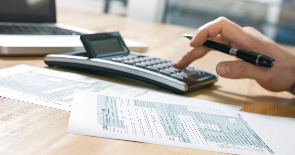 calculator sitting on wood desk with papers nearby