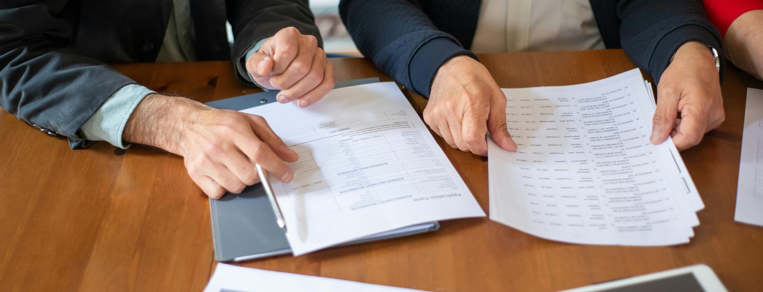 Two Hands Holding and Reviewing Tax Documents