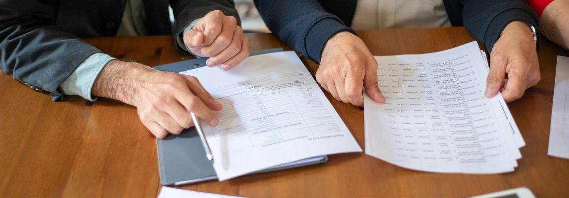 Two Hands Holding and Reviewing Tax Documents