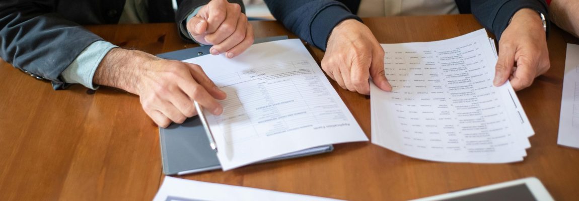 Business papers on wood desk with business professionals