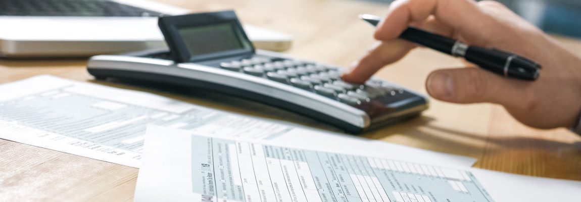 calculator sitting on wood desk with papers nearby